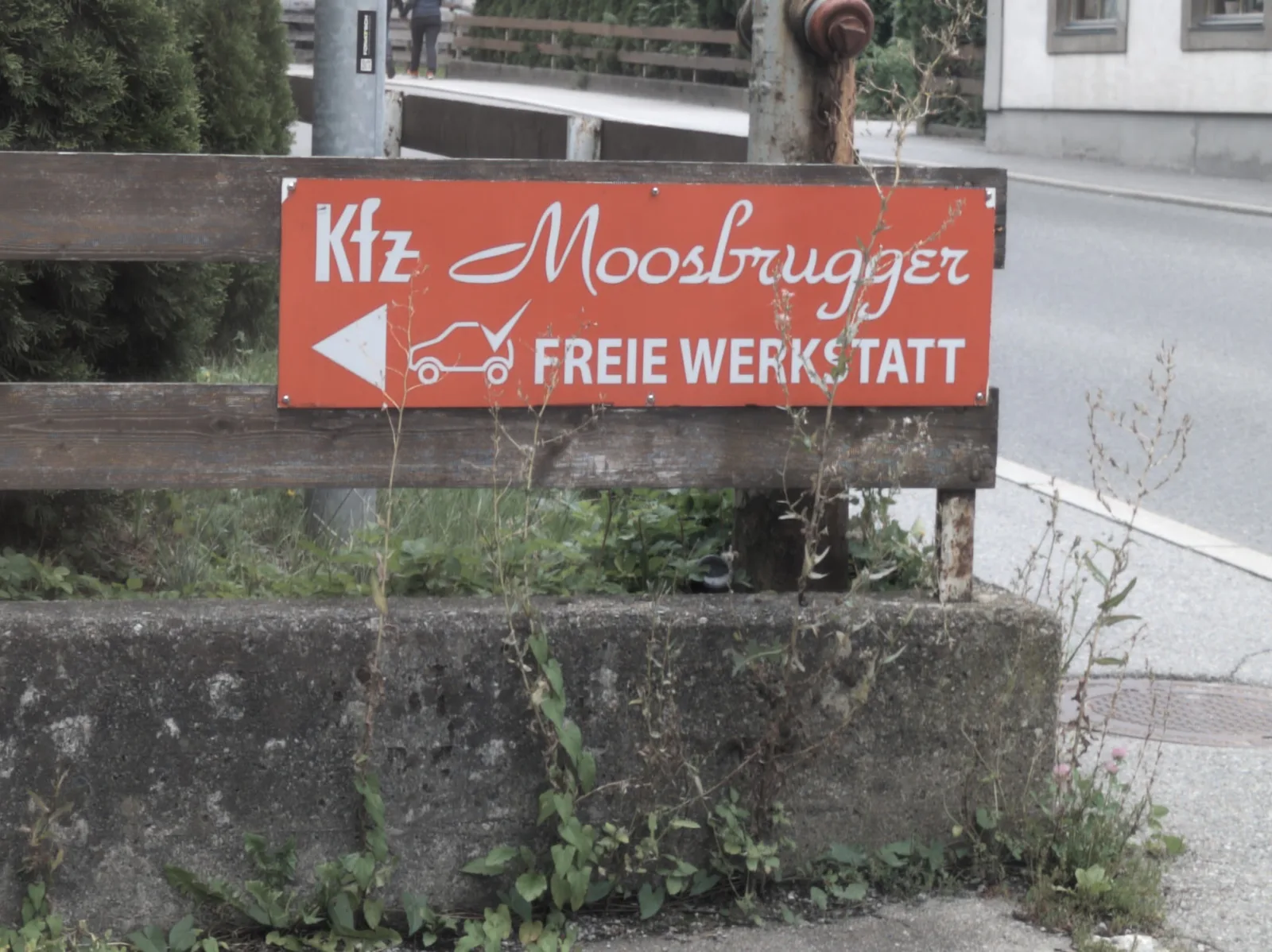 Rot-weißes Straßenschild von KFZ-Moosbrugger, freie Werkstatt